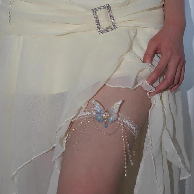 A delicate lace body chain with butterfly charms and tassels, styled on an arm 3